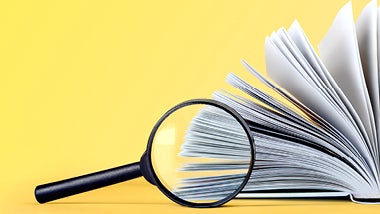yellow background with book and magnifying glass