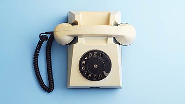 Old receiver telephone against blue background